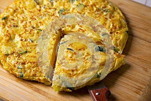 Spanish potato omelette with zucchini and young garlic. Traditional tapa recipe with egg, potato and onion. photo