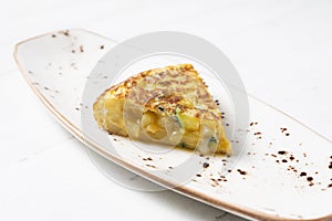 Spanish potato omelette with zucchini and young garlic. Traditional tapa recipe with egg, potato and onion. photo