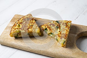 Spanish potato omelette with zucchini and young garlic. Traditional tapa recipe with egg, potato and onion. photo