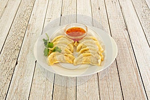 Recipe of traditional Chinese kuo tie dumplings cooked on the grill accompanied by sweet and sour sauce to dip