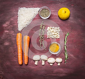 Recipe for vegetarian food rice, peanuts, lemon, spices, mushrooms, thyme, rosemary on wooden rustic background top view close up