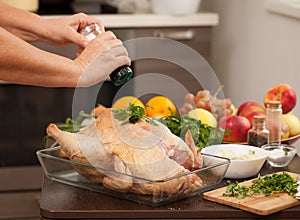 A woman sprinkles salt on the Turkey for roasting