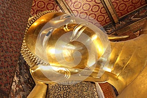 Reclining buddha gold statue face at wat pho in bangkok