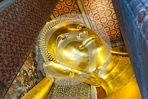 Reclining Buddha gold statue face in Wat Pho, Bangkok