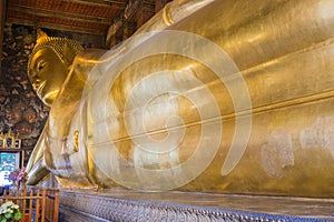 Reclining Buddha gold statue face at Wat Pho, Bangkok, Thailand