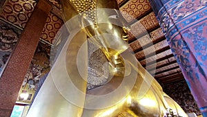 Reclining Buddha gold statue face in Wat Phra Chetupon Vimolmangklararm Wat Pho temple in Thailand