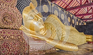 Reclining Buddha gold statue in temple of Thailand.