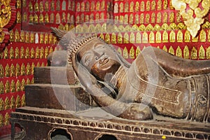 Reclining Buddha statue in a red chapel in Wat Xieng Thong temple in Luang Prabang, Laos.