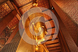 Reclining Gold Buddha statue with close up on the face. Wat Pho, Bangkok, Thailand, Asia