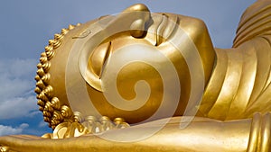 Reclining Golden Buddha face at wat Lampho, Khoyo, Songkhla Thailand. Gold Buddha statue
