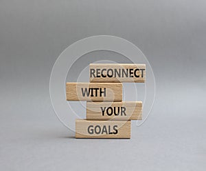Reconnect with your Goals symbol. Wooden blocks with words Reconnect with your goals. Beautiful grey background. Business and
