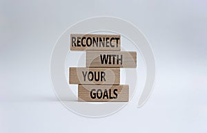 Reconnect with your Goals symbol. Wooden blocks with words Reconnect with your goals. Beautiful white background. Business and