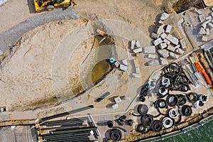 Reconstruction maintenance of pier boardwalk on replacement view a stack black PVC sewer pipes for drainage the ground