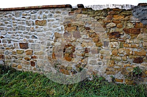 Reconstruction of a stone wall. the repaired part with the moss removed can be seen. blasted wall with pressurized water and fille