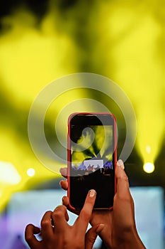 Recording a concert with mobile phone, silhouette of hands with smartphone