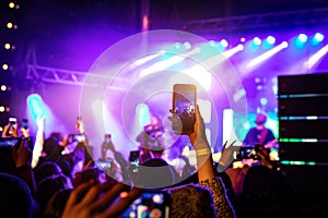 Recording a concert with mobile phone, silhouette of hands with smartphone