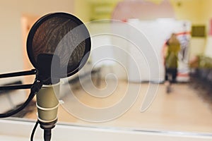 Recording equipment in studio. Studio microphone with headphones and mixer background. Elevated view.