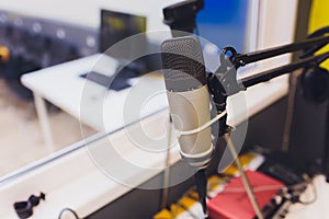 Recording equipment in studio. Studio microphone with headphones and mixer background. Elevated view.