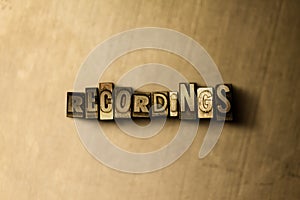 RECORDINGS - close-up of grungy vintage typeset word on metal backdrop