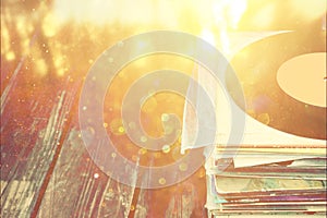 Records stack over wooden table and vintage light leaks filtered image