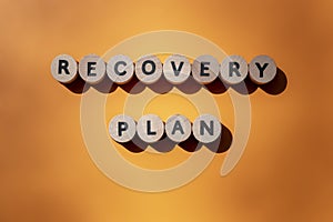 Recovery plan inscription made of wooden letters isolated on orange background. Business concept. Top view. Banner