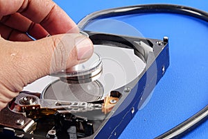 RECOVERY AND REPAIR TECHNOLOGY CONCEPT: Hard Disk Drive HDD with stethoscope isolated on a blue background.