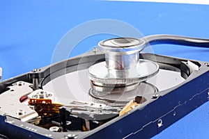 RECOVERY AND REPAIR TECHNOLOGY CONCEPT: Hard Disk Drive HDD with stethoscope isolated on a blue background.