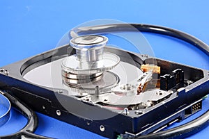 RECOVERY AND REPAIR TECHNOLOGY CONCEPT: Hard Disk Drive HDD with stethoscope isolated on a blue background.