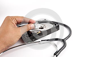 RECOVERY AND REPAIR TECHNOLOGY CONCEPT: Hard Disk Drive HDD with stethoscope isolated on white.