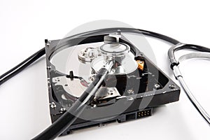 RECOVERY AND REPAIR TECHNOLOGY CONCEPT: Hard Disk Drive HDD with stethoscope isolated on white.