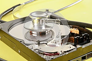 RECOVERY AND REPAIR TECHNOLOGY CONCEPT: Hard Disk Drive HDD with stethoscope isolated on a yellow background.