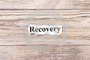 Recovery of the word on paper. concept. Words of Recovery on a wooden background