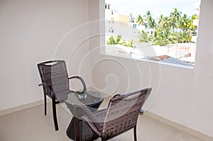 Recreation area on a balcony in hotel a table and chairs overlooking a tropical look
