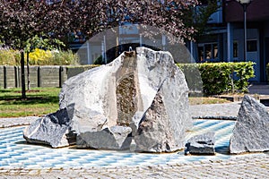 A recreation area with a stone fountain next to a residential building.