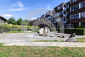 A recreation area with a stone fountain next to a residential building.