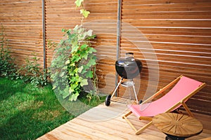 Recreation area in the yard of the house: chairs, barbecue, table photo