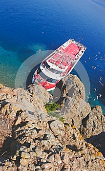 Recreation on the boat near the shore of a mountain. Ship in the bay with swimming people. summer vacation travelling