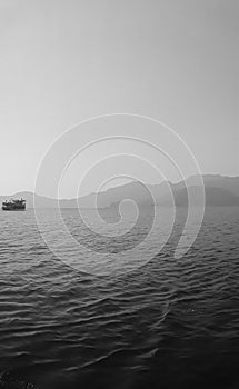 Recreation on the boat near the shore of a mountain. Ship on the water. summer vacation. black and white