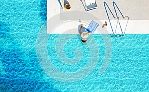 Recreation concept of blue waves water pool background with copy space. Top view from drone above of swimming woman, hat, bikini