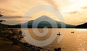 Recreational anglers silhouette fishing in front of Mount Fuji at dusk