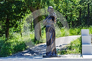 Recreational area along the lake. Sculpture of a girl with a violin