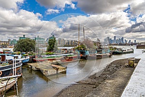 Recreational boats moored on the bank of the River Thames at Butler\'s Wharf in London, England.