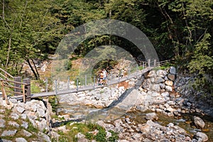 Recreational hikers couple crossing a suspension bridge