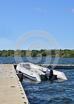 Recreational inflatable white rubber raft with outboard motor