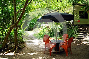 Recreational place in Minca village - a table from an wooden spool and four chairs under a sun umbrella.