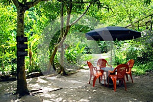 Recreational place in Minca village - a table from an wooden spool and four chairs under a sun umbrella.