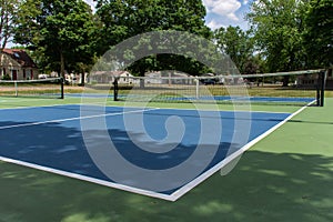 Recreational sport of pickleball court in Michigan, USA looking at an empty blue and green new court at a outdoor park. Ground