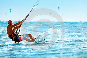 Recreational Sports. Man Kiteboarding In Sea Water. Extreme Sport Action