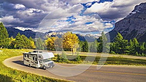 Recreational Vehicle Driving on Autumn Highway In Beautiful Mountains Wilderness photo