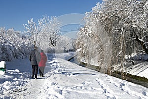 Recreational walkin in snowy winter near river